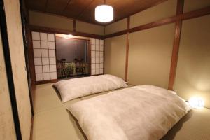 um quarto com 2 camas num quarto com uma janela em Guest House Sawaragi em Quioto