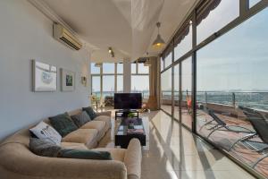 a living room with two couches and a tv at Living Las Canteras Homes - PENTHOUSE FREE PARKING in Las Palmas de Gran Canaria