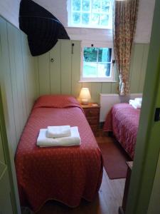 a small room with two beds and a window at Brackenborough Hall Coach House - Stables in Louth