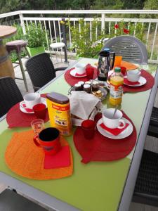 ein Tisch mit Tassen und Teller mit Essen drauf in der Unterkunft La maison familiale in Lagarrigue