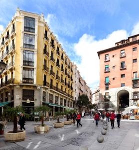 a group of people walking down a city street at Hostal Macarena in Madrid