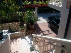 a balcony with potted plants and a car on a house at Apartments Jani in Hvar