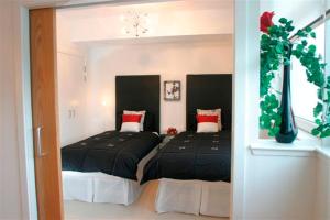 a bedroom with two beds with black and red pillows at River Clyde West End Apartment - 2 Bedrooms in Glasgow