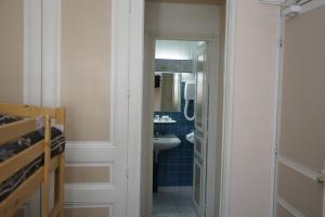 a bathroom with a sink and a toilet and a mirror at Hotel Montsegur in Carcassonne