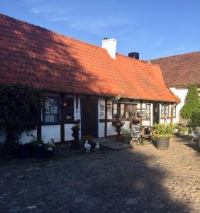 a house with an orange roof with two chickens outside at Solhaga Kullahalvön in Jonstorp