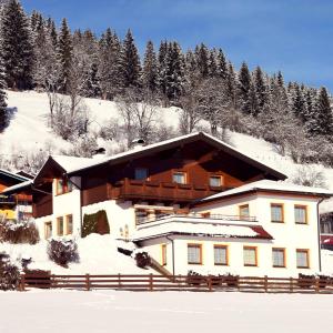 a building with snow on the ground in front at Ferienhaus Steger Maria in Flachau