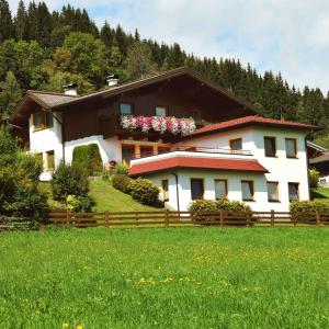 a house with a fence in front of a field at Ferienhaus Steger Maria in Flachau