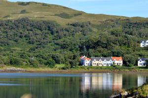 una casa en la orilla de un cuerpo de agua en Craobh Marina Cottages, en Craobh Haven