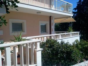 a house with a white railing and a balcony at Apartments Jani in Hvar