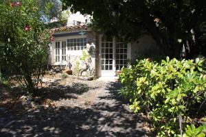 a garden with a white door and some bushes at la maison bleue in Carros