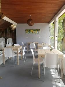 a dining room with tables and white chairs at Pousada Boutique Recanto Do Encanto - GAMBOA - Morro de São Paulo in Morro de São Paulo