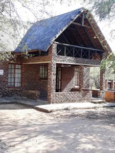 a brick house with a large gambrel roof at African Sky in Marloth Park