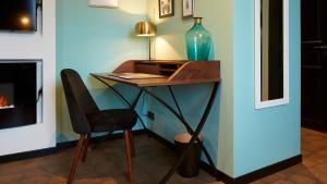 a desk in a room with a chair and a vase at Logis Hôtel La Chaize in Noirmoutier-en-l'lle