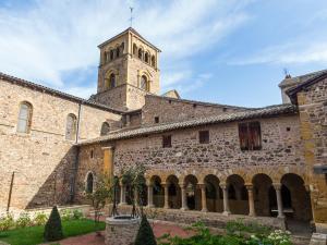 a large stone building with a clock tower at La Chanoinesse in Salles-Arbuissonnas