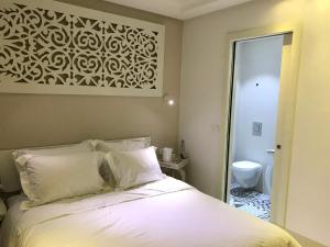 a bedroom with a bed and a bathroom with a toilet at Dar Corniche La Marsa (Adults Only) in La Marsa