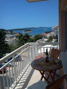a table with a glass of wine on a balcony at Apartments Jani in Hvar
