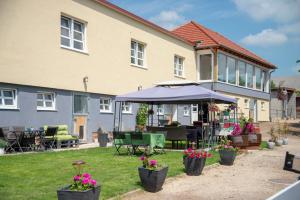 a house with a table and an umbrella in the yard at Ranchzimmer am Hippo-Campus Reit- und Therapiezentrum in Deutsch Haslau