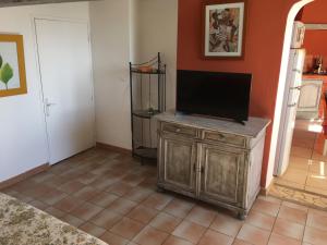 a living room with a television on a wooden cabinet at Luberon & Lavandes in Roussillon