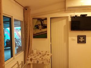 a small dining room with a table and a television at Aquaman @chalong pier in Chalong