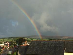 a rainbow in the sky over a city at Exmoor House in Wheddon Cross