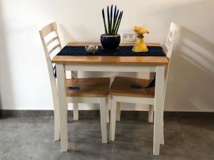 a table with two chairs and a vase with a plant on it at Hilltop Haven in Poriyya