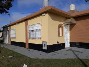 a small yellow building with a white door at Solís e Hipólito Yrigoyen in Mar de Ajó