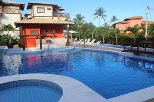 a large swimming pool in front of a house at Praia do Forte Luxuoso Village in Matta de São João
