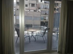 Habitación con vistas a un balcón con mesa y sillas. en Olmos Suites en Córdoba