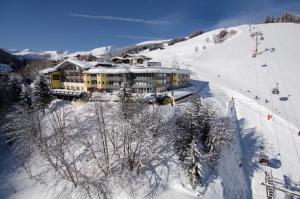 een gebouw op een met sneeuw bedekte helling met een skilift bij Hotel Residenz Hochalm - SKI IN -SKI OUT in Saalbach Hinterglemm