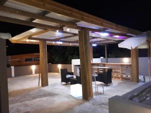 eine Terrasse mit einem Tisch und Stühlen unter einer Pergola in der Unterkunft Residence Les Bambous in Mahébourg