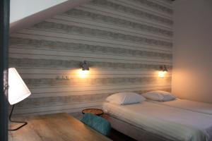 a bedroom with two beds and a wooden wall at Hotel De Hoefpoort in Gemert