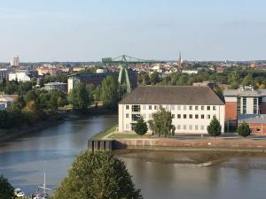 a large white building next to a river at City Weserblick in Bremerhaven