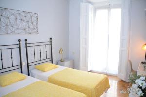 1 dormitorio con 2 camas con sábanas amarillas en Alvaro Residencia, en Madrid