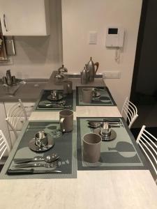 a kitchen table with plates and utensils on it at Bari Lory’s Home in Bari