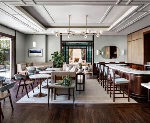 un restaurante con mesas y sillas y un bar en Ambrose Hotel en Los Ángeles