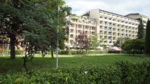 Un gran edificio con un parque enfrente. en Miramar Front Beach Self Catering Apartments No Swim Pool Access, en Sunny Beach