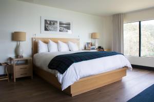 a bedroom with a large bed and a large window at Timber Cove Resort in Jenner