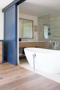 a bathroom with a large tub and a sink at Timber Cove Resort in Jenner