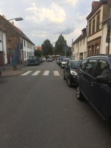 a street with cars parked on the side of the road at Saarlogis Haus Ferienwohnungen St Arnual in Saarbrücken