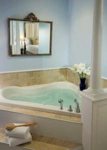 a bath tub in a bathroom with a mirror at Hampton Terrace Inn in Lenox