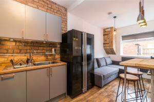 a kitchen with a sink and a refrigerator at Salisbury Street Guesthouse in Long Eaton