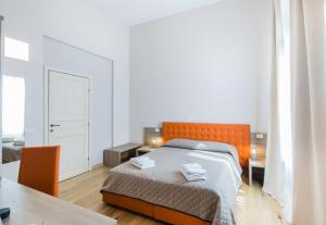 a bedroom with an orange bed and a table at VRooms All'Angolo Del Duomo in Florence
