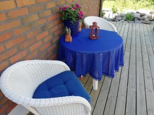 フィエールバッカにあるTallgatan Fjällbackaの青いテーブル(白い籐の椅子2脚、花のテーブル付)