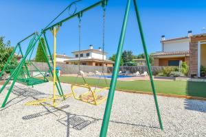 a swing set in a yard with a pool at Casa Cerca De La Playa in Vidreres