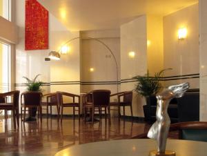 a restaurant with a table and chairs and a statue at Evripides Hotel in Athens