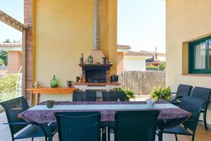 een patio met een tafel en stoelen en een open haard bij Casa Cerca De La Playa in Vidreres