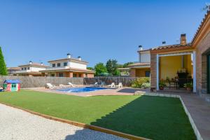 een achtertuin met een zwembad en een huis bij Casa Cerca De La Playa in Vidreres