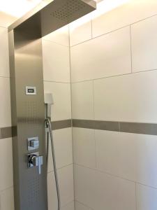 a shower in a bathroom with white tiles at Schwarzwaldmädel in Sankt Peter