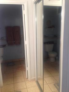 a bathroom with a toilet and a glass door at Molokai Ocean View Condo in Maunaloa