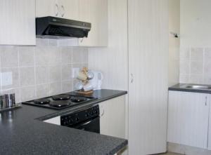 a kitchen with a stove and a counter top at Kingfisher D in Shelly Beach